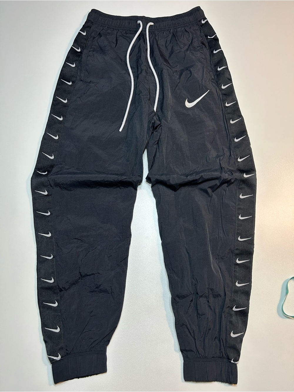 Nike Swoosh Woven Track Pants Black Repeating Logo Tape Cuffed Nylon Joggers